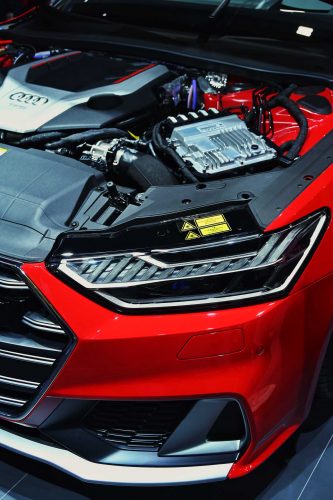 A red car has the hood open to see the engine